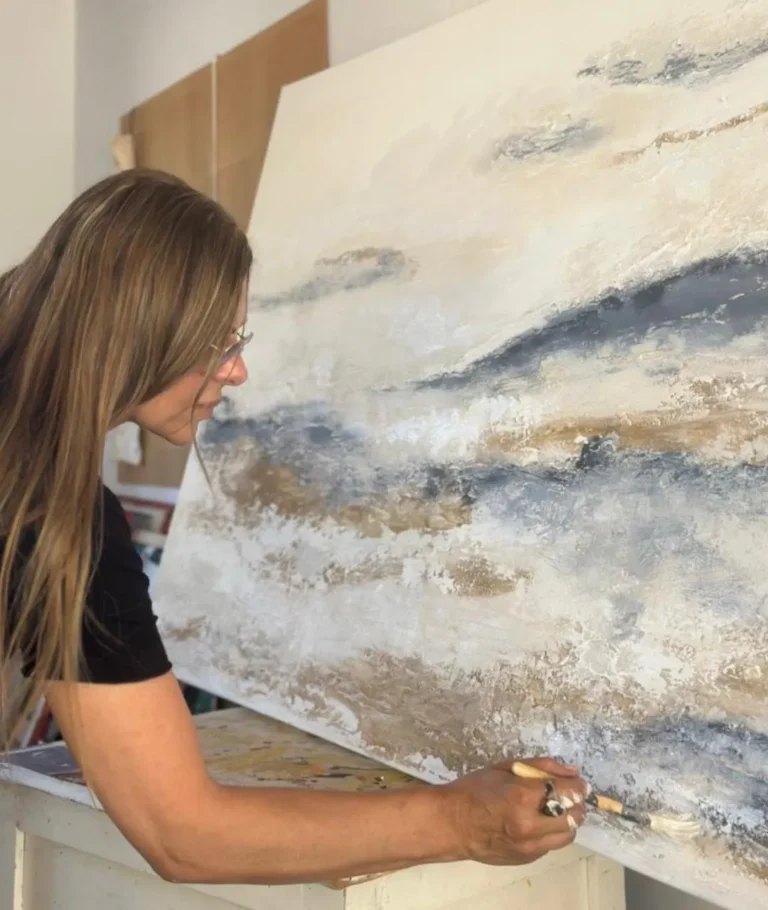 La artista pintando en el atril